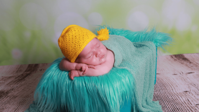 bebê dorminhoco deitado de touca amarela